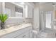 Bright bathroom features a modern vanity, neutral stone counters and a walk-in shower with a glass door at 12009 Wandsworth Dr, Tampa, FL 33626