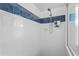 Bright bathroom shower features white tiling and a blue decorative accent stripe at 12009 Wandsworth Dr, Tampa, FL 33626