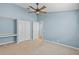 Bright bedroom features a ceiling fan, large closet, desk and light-colored carpet at 12009 Wandsworth Dr, Tampa, FL 33626