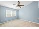 Bright bedroom features a ceiling fan, a window and light-colored carpet at 12009 Wandsworth Dr, Tampa, FL 33626