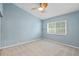 Bright bedroom features a ceiling fan, a window and light-colored carpet at 12009 Wandsworth Dr, Tampa, FL 33626