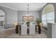 Formal dining room featuring a chandelier, large window, and seating for four at 12009 Wandsworth Dr, Tampa, FL 33626