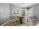 Elegant dining room with a modern chandelier, neutral decor, and a large arched window at 12009 Wandsworth Dr, Tampa, FL 33626