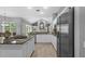 Bright kitchen featuring central island cooktop, stainless appliances, and a view of the living room at 12009 Wandsworth Dr, Tampa, FL 33626