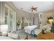 A view of the spacious bedroom with light colored walls, a ceiling fan, and light colored furnishings at 12009 Wandsworth Dr, Tampa, FL 33626