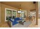 Enjoy a covered patio with a ceiling fan, TV, furniture, and dining area at 12009 Wandsworth Dr, Tampa, FL 33626