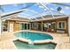 A private screened-in pool area features an outdoor kitchen and dining space at 12009 Wandsworth Dr, Tampa, FL 33626