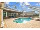 Inviting backyard pool features a spa and brick paved patio under screened enclosure at 12009 Wandsworth Dr, Tampa, FL 33626
