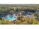Aerial view of a community pool and tennis courts surrounded by mature trees at 12009 Wandsworth Dr, Tampa, FL 33626