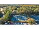 Overhead shot of tennis courts and parking lot bordered by dense foliage and community buildings at 12009 Wandsworth Dr, Tampa, FL 33626