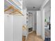 Spacious walk-in closet featuring carpeted flooring, white shelving units, and wooden hangers at 12009 Wandsworth Dr, Tampa, FL 33626