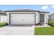 Charming single-Gathering home featuring a two-car garage, manicured lawn, and neutral color palette at 12074 Manassas Ave, Weeki Wachee, FL 34614