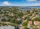 Expansive aerial view shows neighborhood with mature trees, waterfront views, and the home marked by a red pin at 122 Miramar Ne Blvd, St Petersburg, FL 33704
