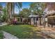 Lush backyard with mature trees, a well-manicured lawn, and cozy pergola-covered seating areas at 122 Miramar Ne Blvd, St Petersburg, FL 33704