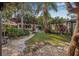 Spacious backyard featuring lush landscaping, stone pathways, and string lighting, perfect for outdoor gatherings and relaxation at 122 Miramar Ne Blvd, St Petersburg, FL 33704