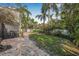Backyard with a well-maintained lawn, garden beds, mature trees, and a stone pathway, perfect for outdoor activities at 122 Miramar Ne Blvd, St Petersburg, FL 33704