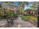 Charming backyard with a stone patio, elegant outdoor furniture, and vibrant landscaping at 122 Miramar Ne Blvd, St Petersburg, FL 33704