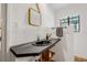 Bathroom featuring a dark vanity, unique faucet, mirror, towel rack, and white walls at 122 Miramar Ne Blvd, St Petersburg, FL 33704