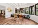 Bright dining room featuring built-in bench seating, unique light fixture, and large windows showcasing lush outdoor views at 122 Miramar Ne Blvd, St Petersburg, FL 33704