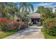 Beautiful exterior showcasing lush blooming landscaping and a private gated entry to the attractive home at 122 Miramar Ne Blvd, St Petersburg, FL 33704