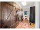 Hallway featuring wooden barn doors, terracotta tile floors, a window, and a chair at 122 Miramar Ne Blvd, St Petersburg, FL 33704