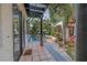An inviting pool area with tile patio, surrounding lush greenery, and black-framed sliding doors at 122 Miramar Ne Blvd, St Petersburg, FL 33704