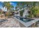 Beautiful rectangular pool surrounded by a stone patio, palm trees and lush landscaping at 122 Miramar Ne Blvd, St Petersburg, FL 33704