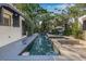 Stylish backyard pool with stone patio, lounge seating, and surrounding lush greenery at 122 Miramar Ne Blvd, St Petersburg, FL 33704