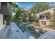 Inviting pool area features a modern pool with surrounding deck, and lush tropical landscaping, perfect for relaxation at 122 Miramar Ne Blvd, St Petersburg, FL 33704