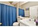 Cozy bathroom featuring a large mirror, bright lighting, and a classic blue shower curtain at 12716 Evington Point Dr, Riverview, FL 33579
