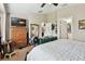 Bedroom with ceiling fan, wooden dresser, ensuite bathroom, and an accent wall mirror at 12716 Evington Point Dr, Riverview, FL 33579
