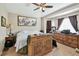 Bedroom with a ceiling fan, large window, dresser, and neutral earth tone color palette at 12716 Evington Point Dr, Riverview, FL 33579
