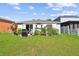 View of the home's exterior showcasing a landscaped yard with a built-in grill perfect for outdoor gatherings at 12716 Evington Point Dr, Riverview, FL 33579
