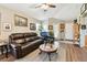 Comfortable living room featuring a leather sofa, wood floors, and natural lighting at 12716 Evington Point Dr, Riverview, FL 33579