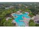 Aerial view of a large community pool and tanning deck surrounded by lush landscaping and palm trees at 12716 Evington Point Dr, Riverview, FL 33579