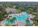 Bird's eye view of a community pool featuring connected pools, tanning decks, a covered area, and tropical foliage at 12716 Evington Point Dr, Riverview, FL 33579