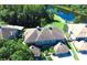 Aerial view of the home, showing the roof, backyard, and the nearby lake and trees at 14116 Trouville Dr, Tampa, FL 33624