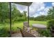Relaxing back patio with seating overlooking a lush, green lawn and a serene pond at 14116 Trouville Dr, Tampa, FL 33624