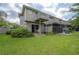 A well-maintained backyard with a patio, screened enclosure, and green lawn at 14116 Trouville Dr, Tampa, FL 33624