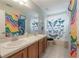 This bathroom features a long mirror, double sinks, and unique shower curtain at 14116 Trouville Dr, Tampa, FL 33624