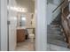 Cozy bathroom with a wooden cabinet sink, toilet, and tiled flooring near the carpeted stairs at 14116 Trouville Dr, Tampa, FL 33624