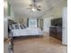 Spacious bedroom with light wood floors, neutral wall color, and large bed with pillows at 14116 Trouville Dr, Tampa, FL 33624