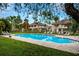 Enjoy this community pool with lounge chairs surrounded by lush greenery on a bright, sunny day at 14116 Trouville Dr, Tampa, FL 33624