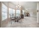 A dining area featuring a glass table, chandelier, and large windows for ample natural light at 14116 Trouville Dr, Tampa, FL 33624