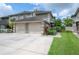 Exterior view of the townhome with a two-car garage and a well-maintained lawn at 14116 Trouville Dr, Tampa, FL 33624