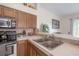 Kitchen features stainless steel appliances, marble countertops, and a sink with a tile backsplash at 14116 Trouville Dr, Tampa, FL 33624