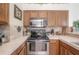 Close-up of the kitchen showcasing stainless steel appliances, tiled backsplash, and ample counter space at 14116 Trouville Dr, Tampa, FL 33624