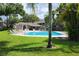 Nice community pool with a lounging area, palm trees, and grass at 14116 Trouville Dr, Tampa, FL 33624
