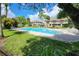 Community pool surrounded by lush green grass and trees provides a tranquil setting at 14116 Trouville Dr, Tampa, FL 33624