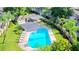 Aerial view of pool area featuring lush vegetation and community building at 14116 Trouville Dr, Tampa, FL 33624